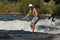 Young man surfing a river wave with helmet