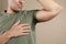 Young man with sweat  on beige background, closeup. Using deodorant