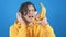 A young man in a sweatshirt sings in a banana on a blue background.