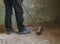 A young man sweeps the floor with a broom.