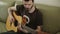 A young man in a t-shirt playing the guitar.