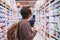 Young man with a tablet chooses products in a supermarket