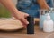 Young man taking deodorant from table in bathroom