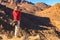 Young man taking photos of mountain range Red Sea Hills in Arabian desert, Egypt