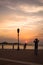 A young man taking picture of her girlfriend during cloudy sunset at Corniche Abu Dhabi, UAE