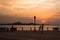 A young man taking picture of her girlfriend during cloudy sunset at Corniche Abu Dhabi, UAE