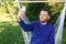 Young man taking selfie with mobile phone in hammock outdoors