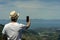 Young man taking a selfie with smartphone at Takaka Hill, Hawkes Lookout. New Zealand