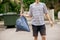 young man taking trash bag with garbage away