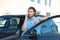 Young man talking on phone near modern car