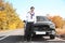 Young man talking on phone near modern car