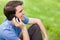 Young man talking on the phone while sitting on the grass