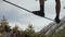 A young man teeters on a slackline in the mountains of the north Caucasus. Close-up of athlete legs amid snow-covered