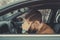 A young man of thirty years, holding his head, having a headache, driving a car. Poor health while driving