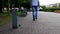 A young man throws a plastic bottle in the city near a trash can, a passer-by goes and picks up trash after him and