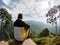 A young man on top sits on a stone near Ella, Sri Lanka