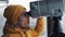 Young man tourist looking through binoculars or telescope on snowy mountains. Travel, nature, hiking conception