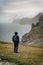 Young man tourist standing on Footpath to cliff Traelanipan and lake Sorvagsvatn located on the island of Vagar