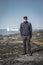 Young man tourist standing in front of iceberg. View towards Icefjord in Ilulissat. Icebergs from Kangia glacier in