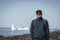 Young man tourist standing in front of iceberg. View towards Icefjord in Ilulissat. Icebergs from Kangia glacier in