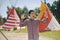 Young man tourist take photo selfie / video communication and smiling on the background teepee / tipi- native indian house. Man in