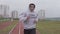 Young man training at stadium in morning. Boxer running in hoodie outdoors