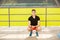 Young man training yoga outdoors. Sporty guy makes stretching exercise on a blue yoga mat, on the sports ground