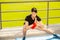 Young man training yoga outdoors. Sporty guy makes stretching exercise on a blue yoga mat, on the sports ground