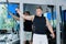 Young man trains the muscles of the shoulder girdle using a weight machine