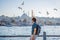 Young man traveler in pinc dress enjoying great view of the Bosphorus and lots of seagulls in Istanbul