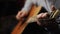 A young man tunes an acoustic guitar plucking the strings and musical notes