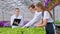 A young man and two women in white coats and black aprons. Three scientists, biologists or agronomists examine and