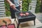 Young man use meat tongs grills sliced meat.