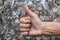 Young man uses his hand to show the great sign by raising his thumb and doing a fingerprint scan test to unlock the most secure