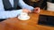 A young man uses smart phone and drink coffee while sitting at the bar