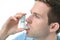 Young man using an asthma inhaler