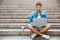 Young man using laptop while sitting on the staircase outdoors