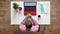 Young man using phone with chroma key, topshot, sitting behind desk with laptop and coffee