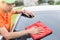 Young man using red microfiber cloth cleaning body of new silver