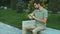 Young man using smartwatch while sitting on the bench in the park