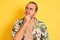 Young man on vacation wearing summer shirt striped t-shirt over isolated yellow background with hand on chin thinking about