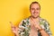 Young man on vacation wearing summer shirt striped t-shirt over isolated yellow background smiling and looking at the camera