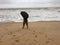 A young man venturing into the sea with an umbrella