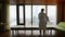 Young man waking up at luxury apartments hotel. Successfull male person wearing bathrobe and stretching doing morning