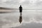 A young man walking alone on a smooth beach at Witsand, South Africa