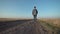 Young man walking away down a rural road