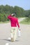 Young man walking down highway with empty gas can