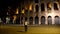 Young man walking in front of Colosseum in Rome, Italy