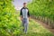 Young man walking in garden path between trees