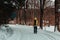 Young man walking in winter czech landscape on forest path in yellow jacket